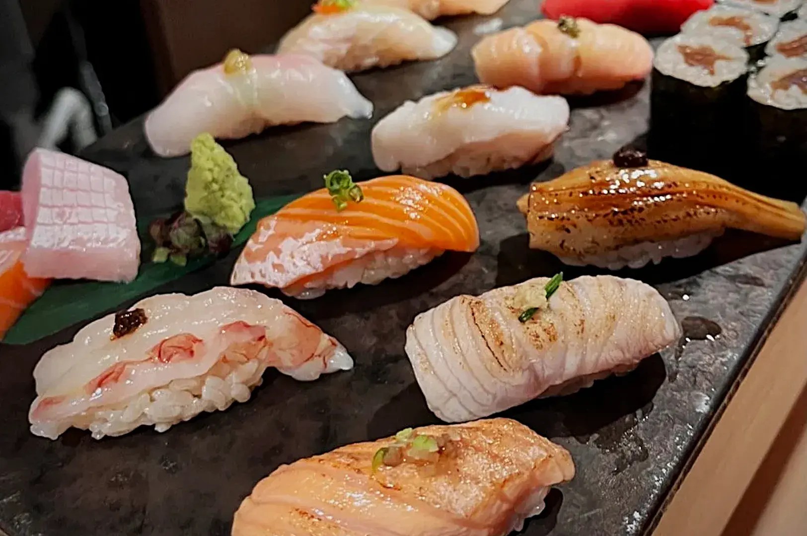 Una selección de sushi con distintos pescados sobre una bandeja.