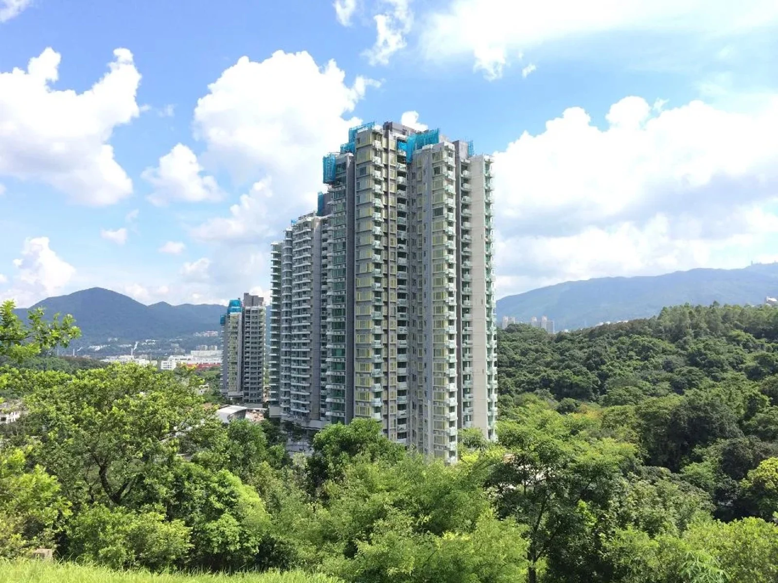 Edificios residenciales junto a los cerros verdes de Tai Po